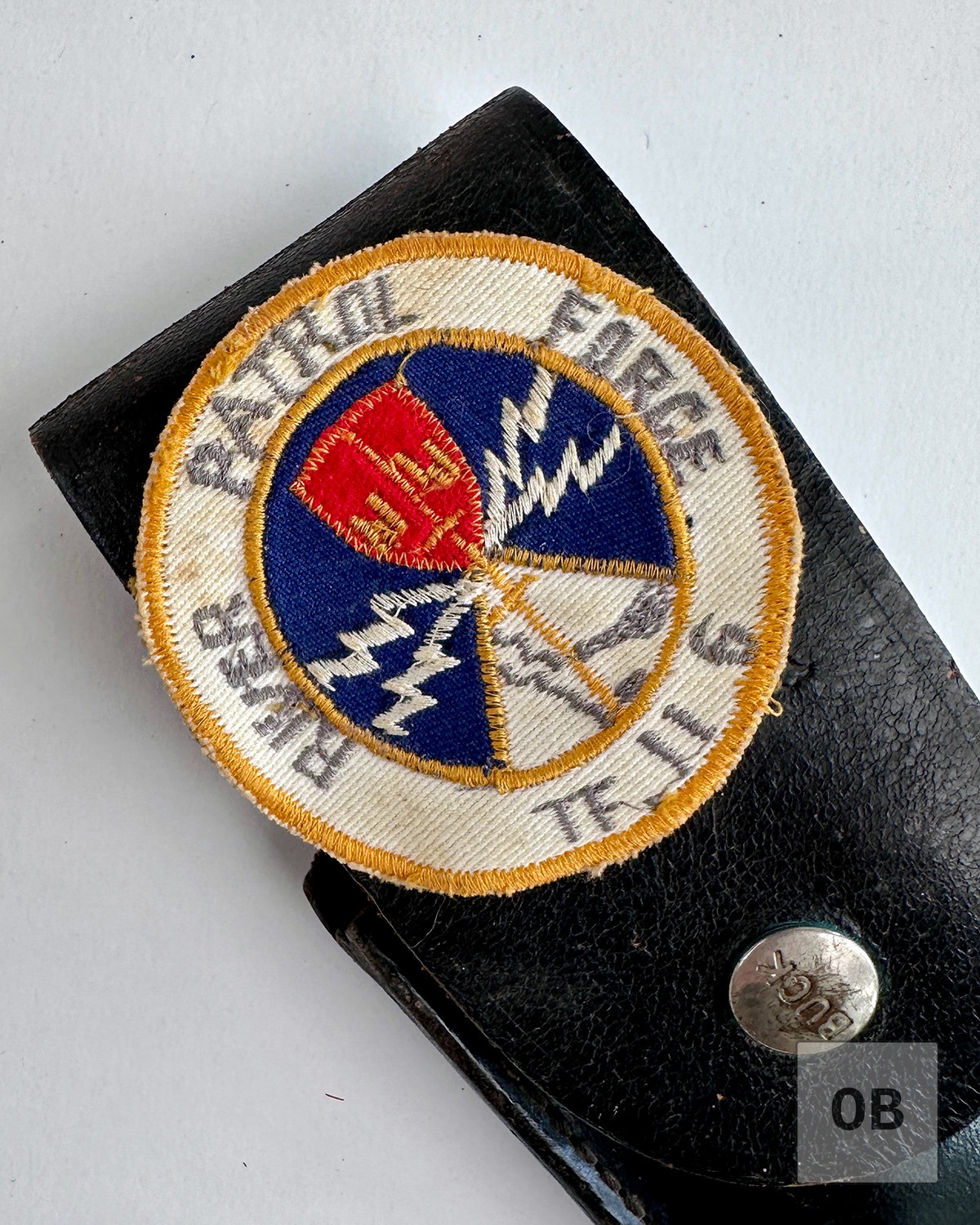Detail of the round River Patrol Force cloth patch on the knife's sheath.
