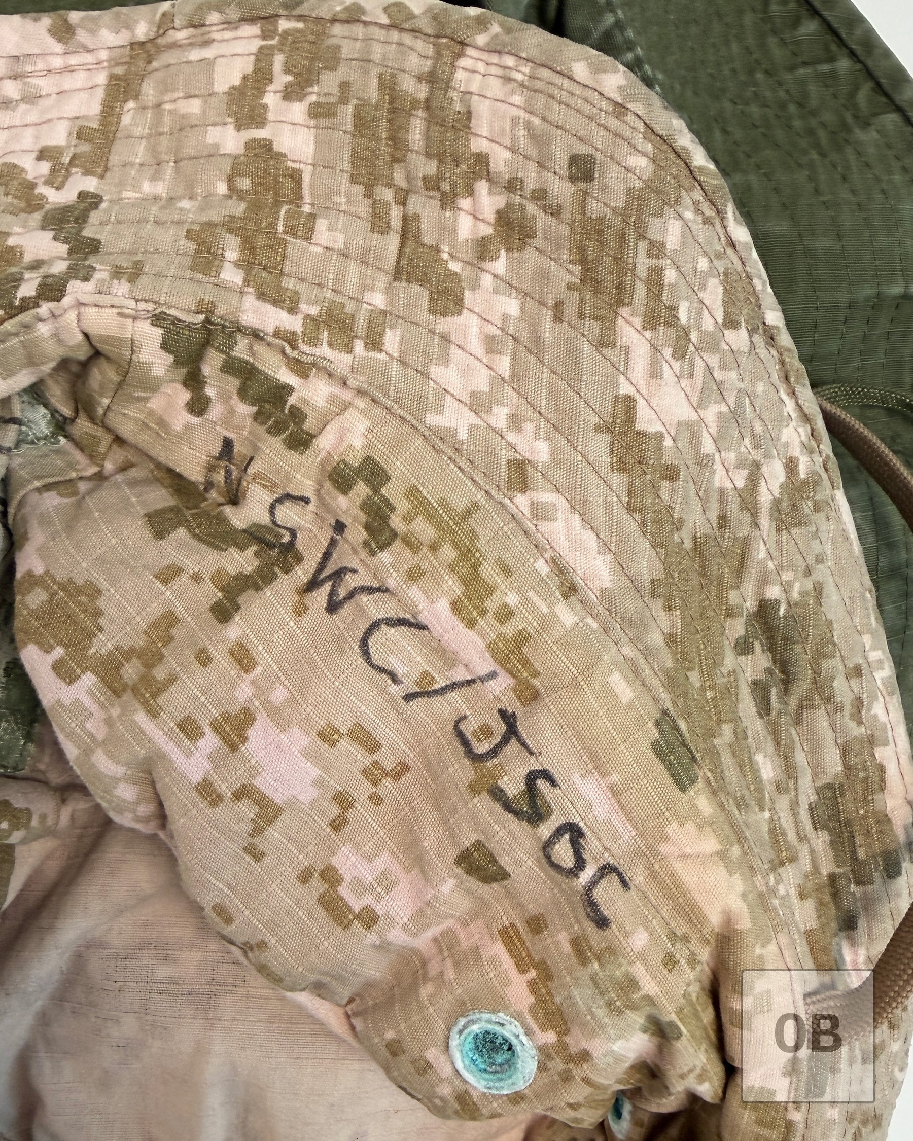 The letters NSWC over JSOC written in black marker inside the AOR1 hat's crown.