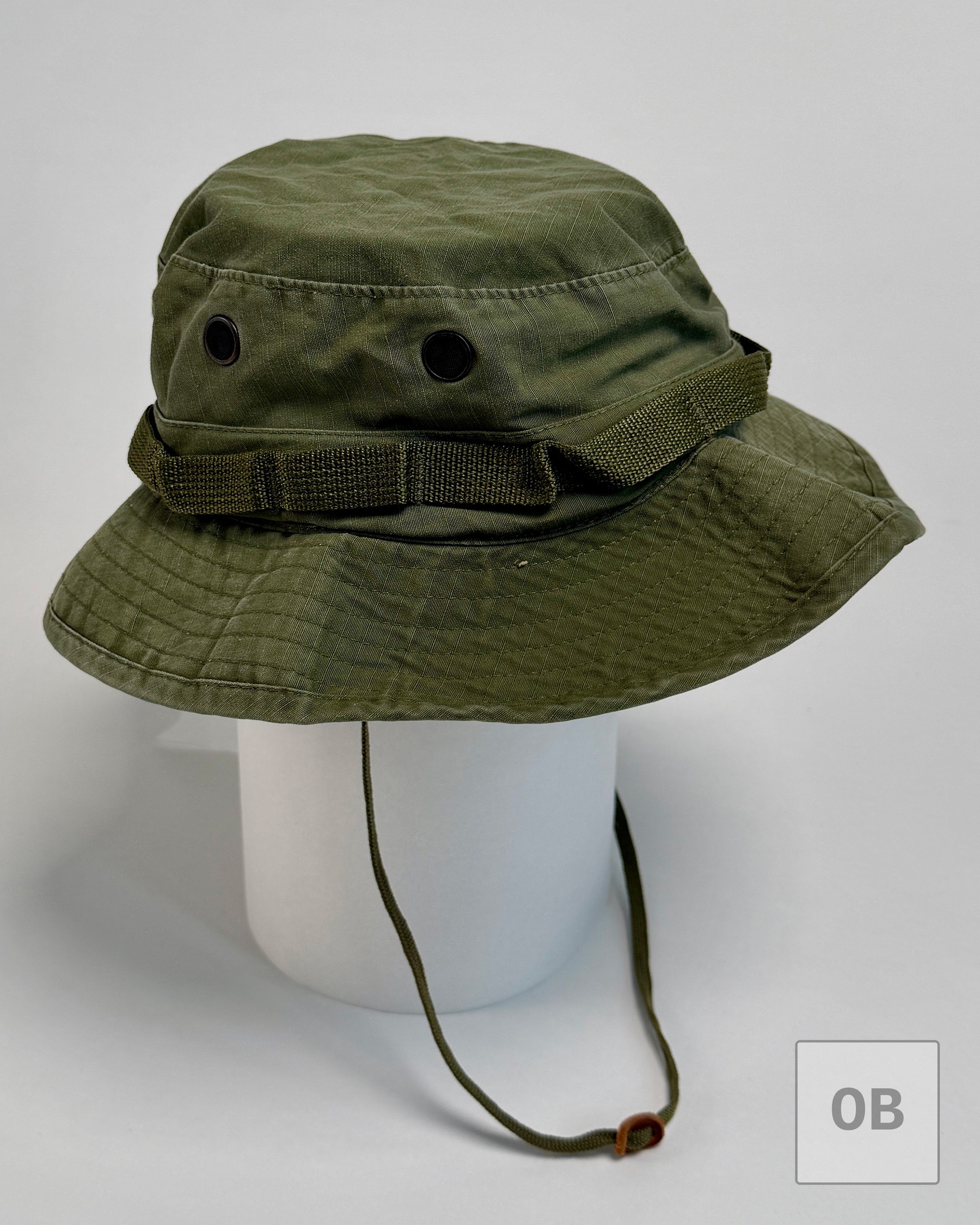 Side view of a solid olive drab ripstop boonie hat on a display form, with adjustable chin cord.