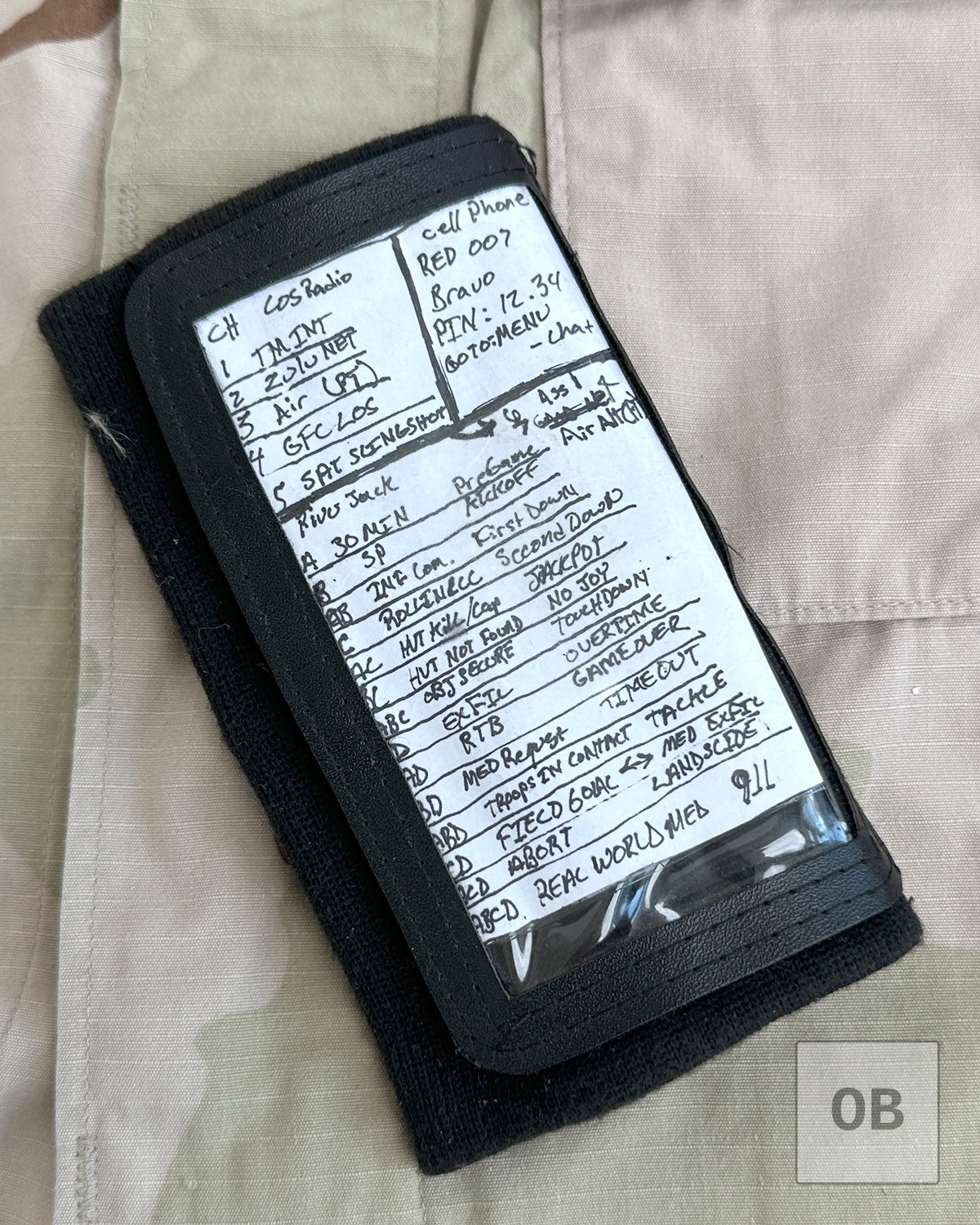 Wrist coach closed, showing the handwritten radio channel assignments, brevity codes, and secure handset login notes.