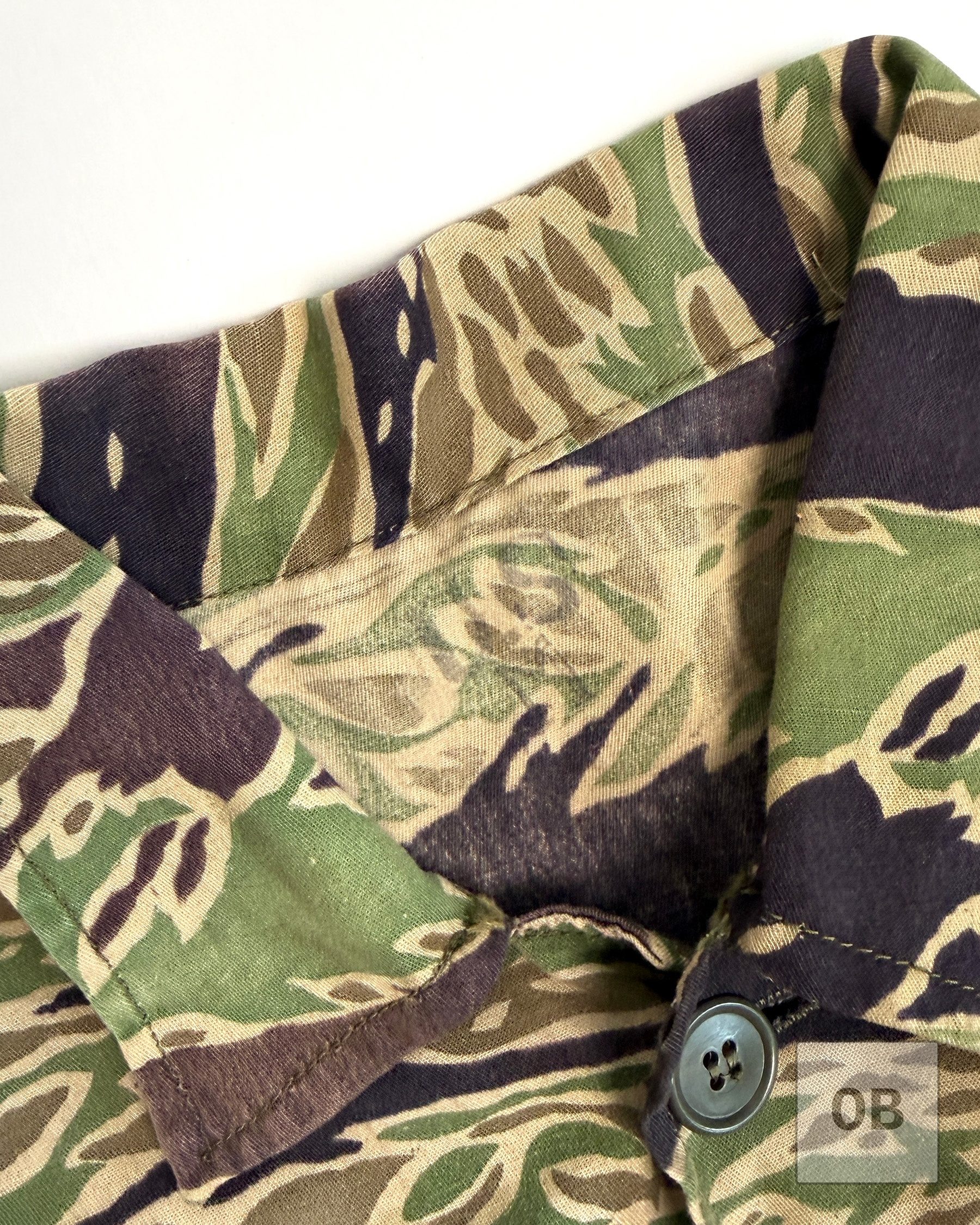 Close-up of the inside collar of the late war lightweight tigerstripe shirt, showing a faint US-M size rubber stamp.