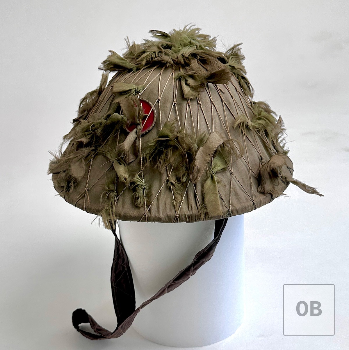 Early Viet Cong camouflage helmet with fishnet camouflage and Viet Minh badge.