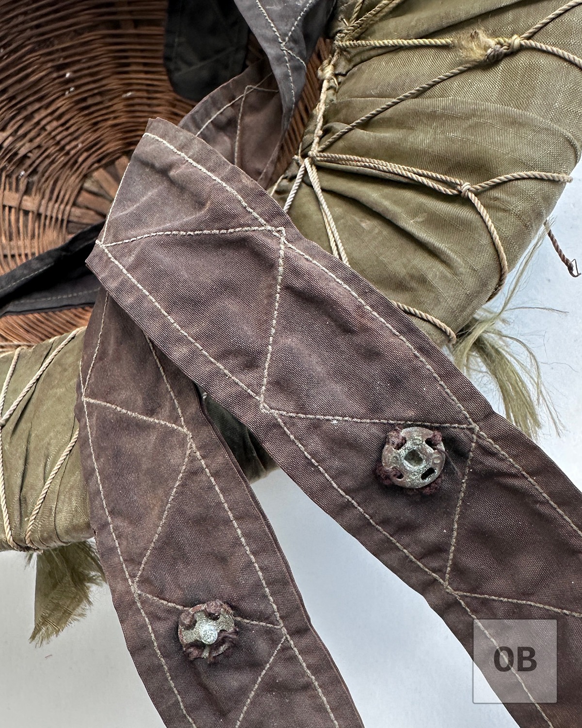 Glove snap used as a simple chinstrap adjustment on a Viet Cong camouflage helmet.