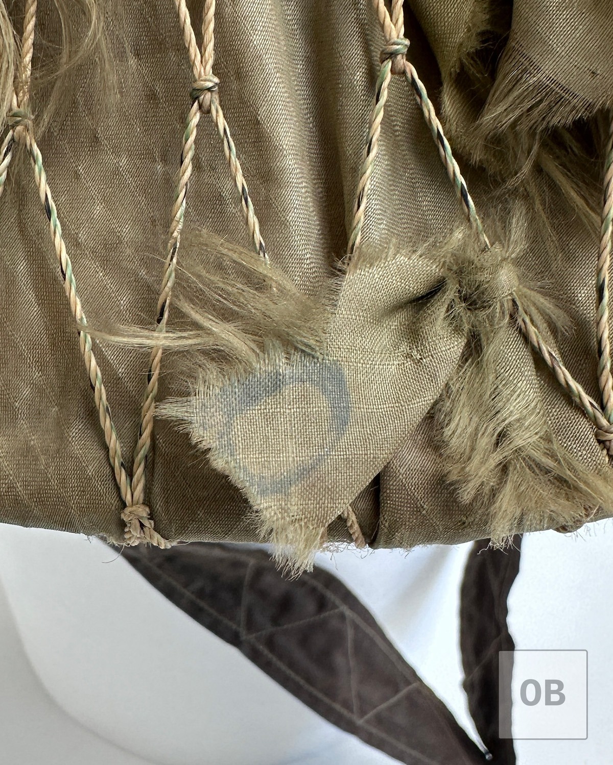Printed fabric remnant visible on a parachute nylon camouflage strip.