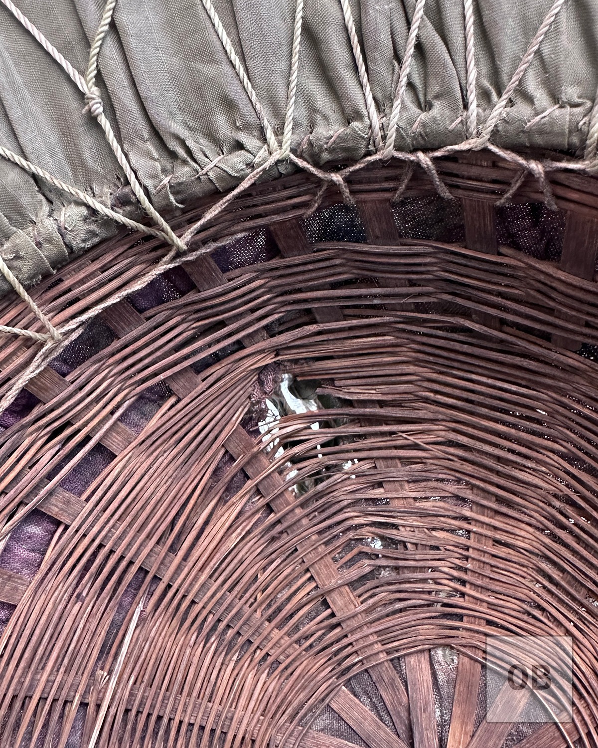 Projectile damage through the woven reed shell of an early Viet Cong camouflage helmet.