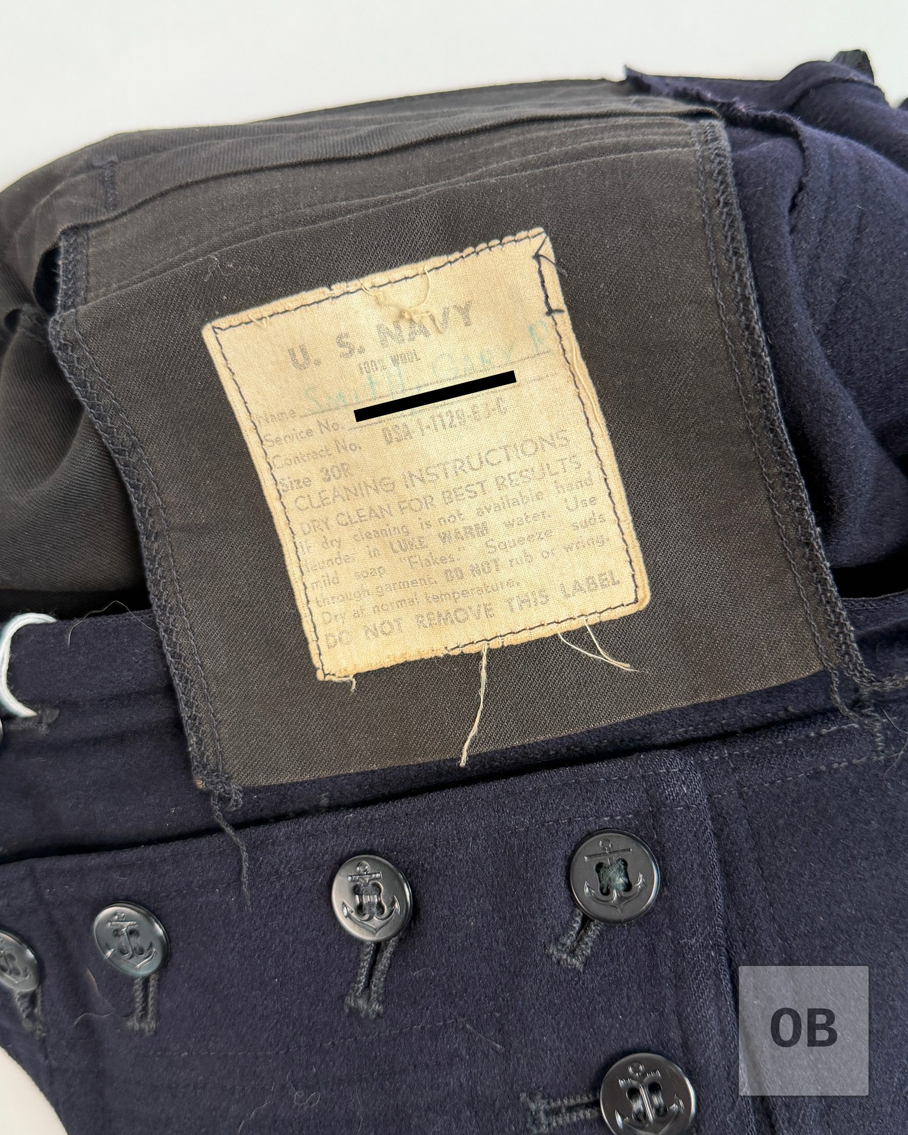 U.S. Navy wool dress blue trousers issue label, size 30R, from a SEAL Team 1 uniform group, with the identifying number covered.