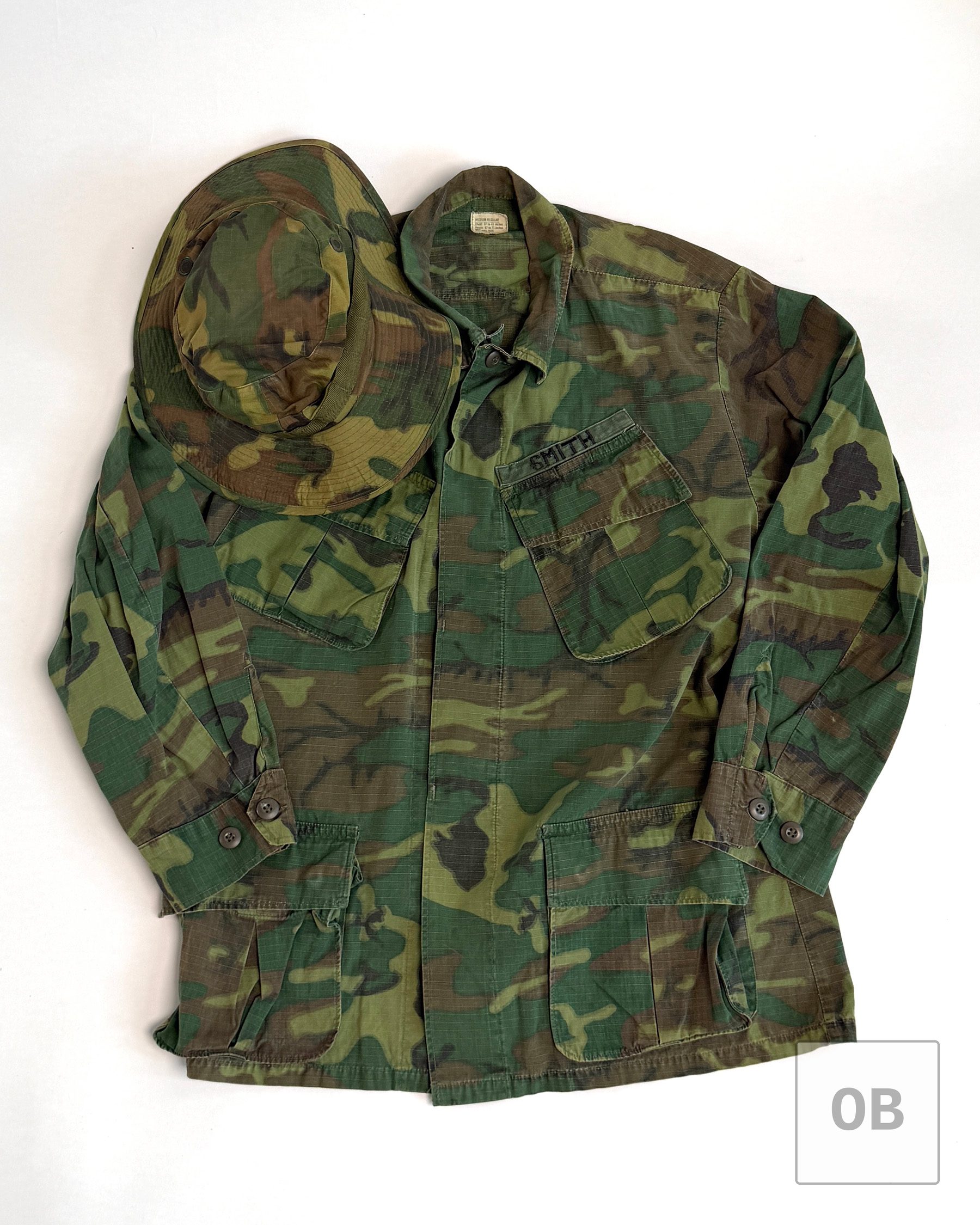 Vietnam War Navy SEAL Team 1 ERDL camouflage OP Top jungle jacket with a theater-made SMITH tape, shown with an early wide-brim ERDL boonie hat.
