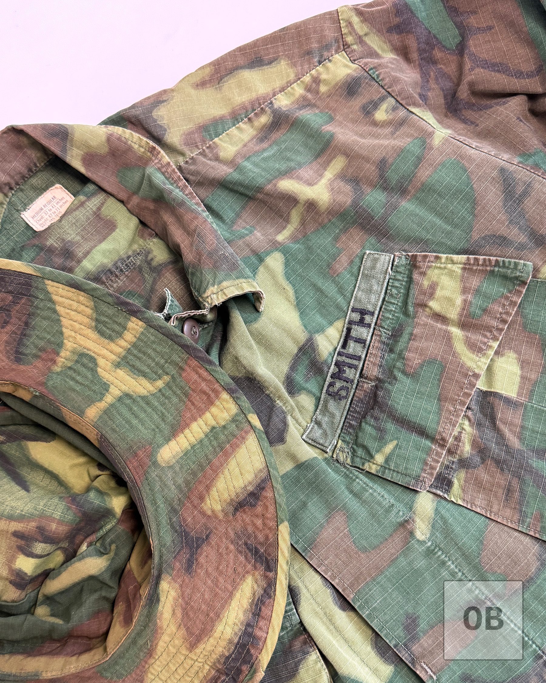 Theater-made SMITH tape on a SEAL Team 1 ERDL jungle jacket pocket, with the early wide brim of an ERDL boonie hat in the foreground.