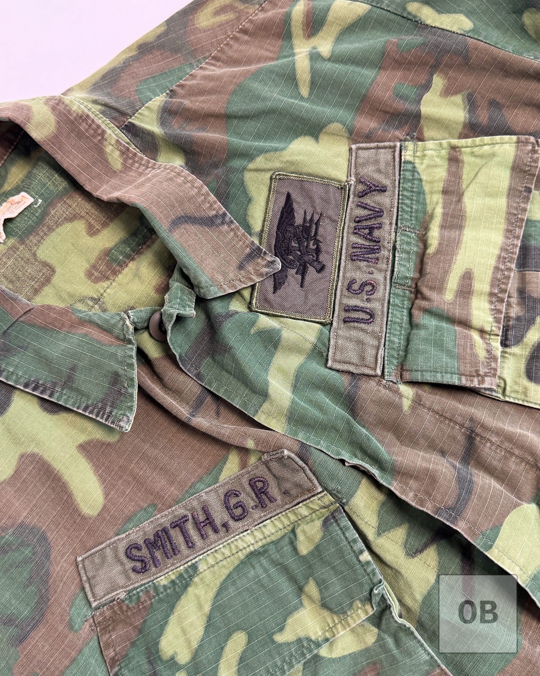 Theater-made SMITH, G.R. and U.S. NAVY tapes and a SEAL Trident on poly-blend twill on a Vietnam War SEAL Team 1 ERDL jacket.