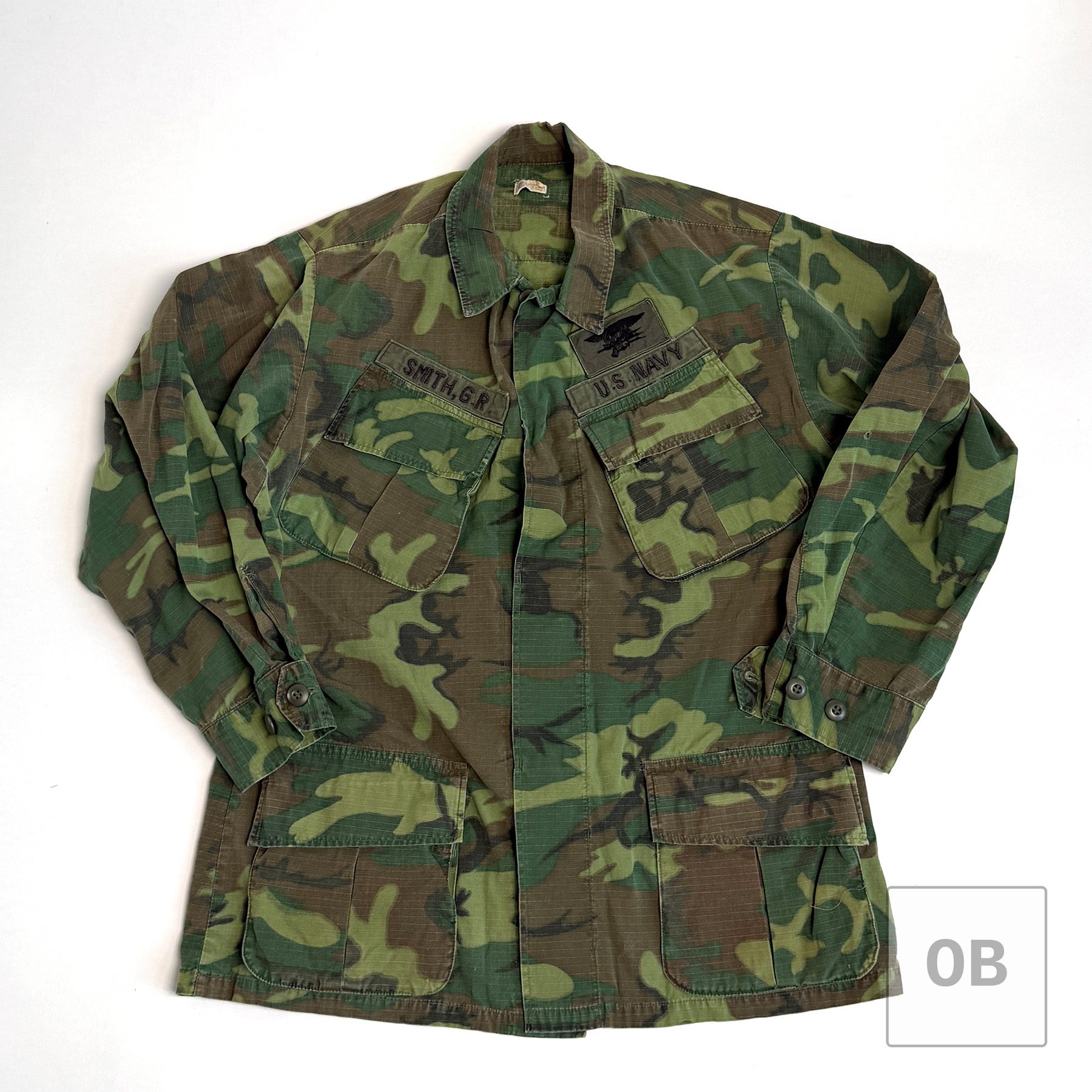 Vietnam War Navy SEAL Team 1 ERDL camouflage jungle jacket with theater-made SMITH, G.R. and U.S. NAVY tapes and a SEAL Trident.