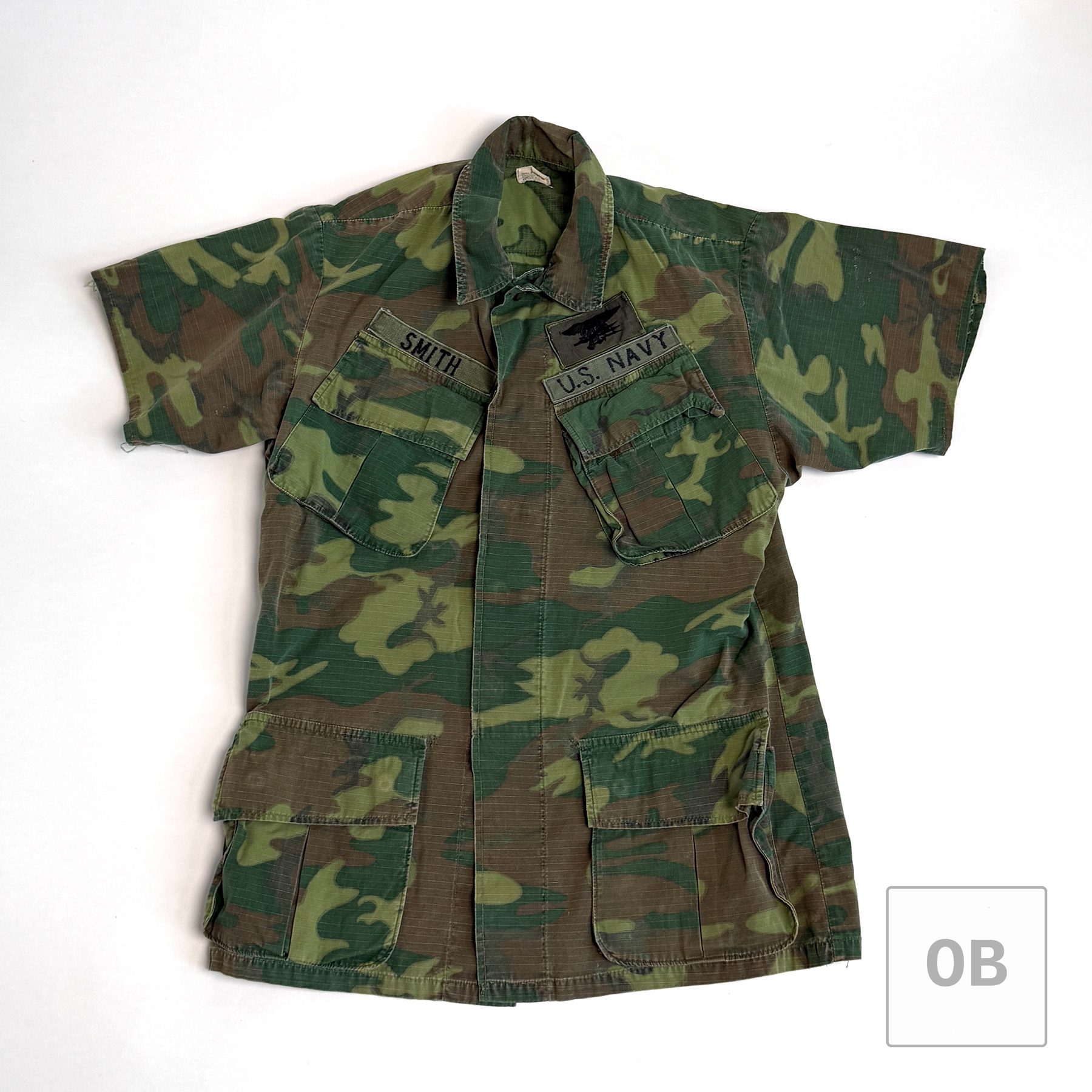 Vietnam War Navy SEAL Team 1 short-sleeve ERDL camouflage jungle jacket with SMITH and U.S. NAVY tapes on cotton webbing and a SEAL Trident.