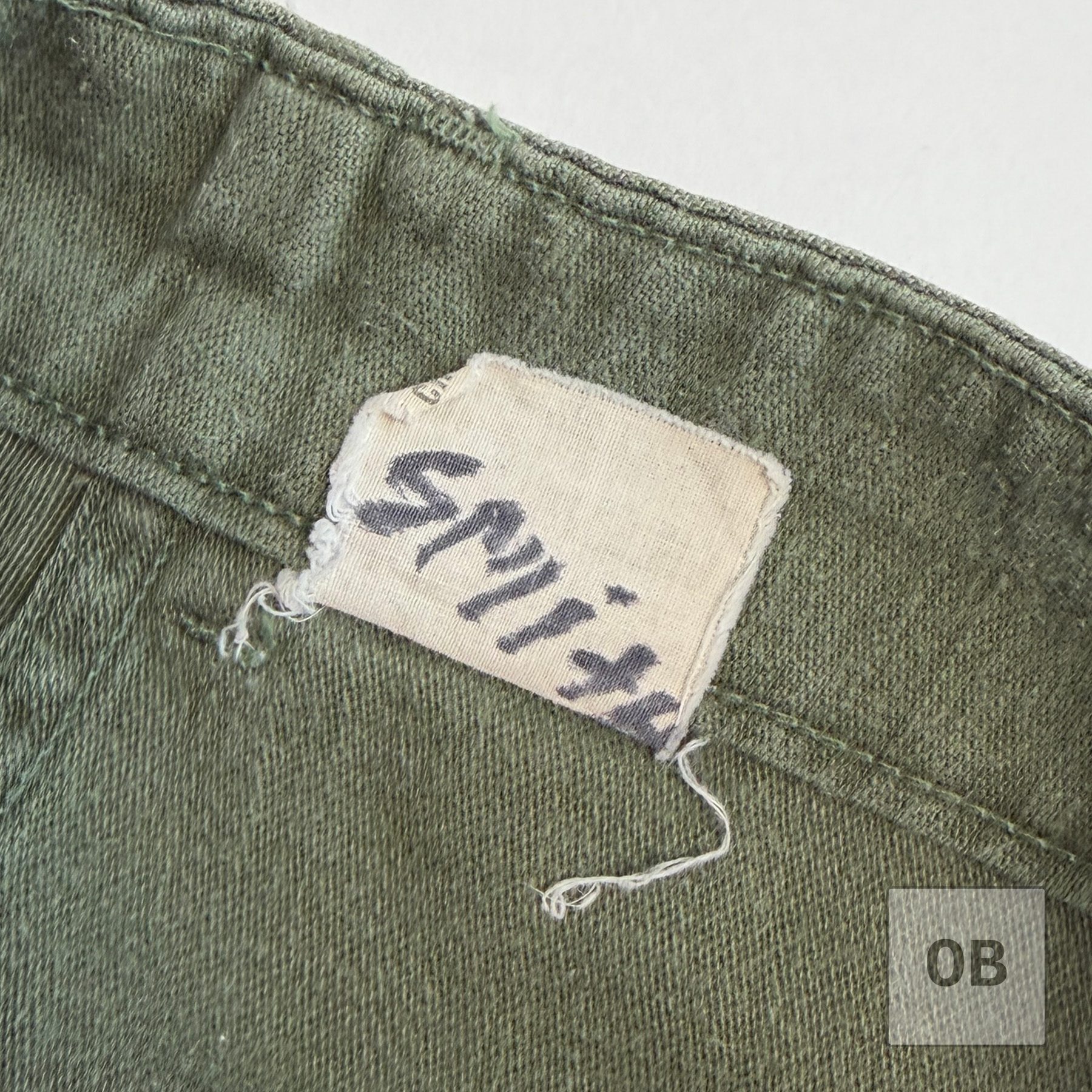 Interior label of SEAL Team 1 operator Gary R. Smith's OD utility trousers with Smith handwritten in ink.
